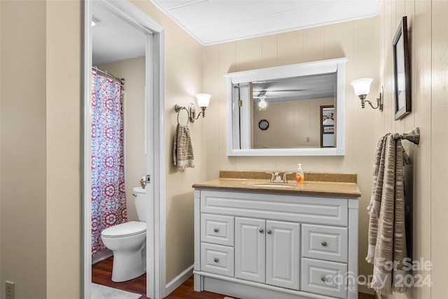 bathroom featuring wood-type flooring, toilet, crown molding, and vanity