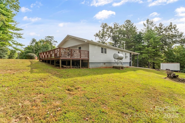 view of side of property with a wooden deck, a lawn, and a shed