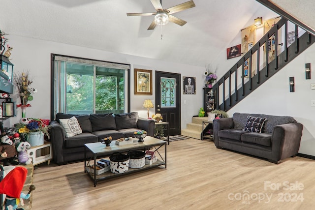 living room featuring lofted ceiling, ceiling fan, a textured ceiling, and light hardwood / wood-style flooring