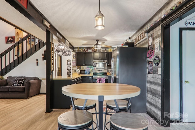 dining space featuring a textured ceiling, ceiling fan, and light hardwood / wood-style floors