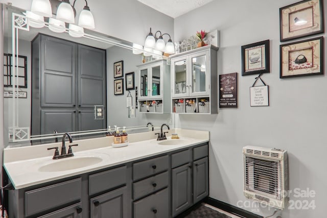 bathroom featuring a textured ceiling, vanity, and heating unit