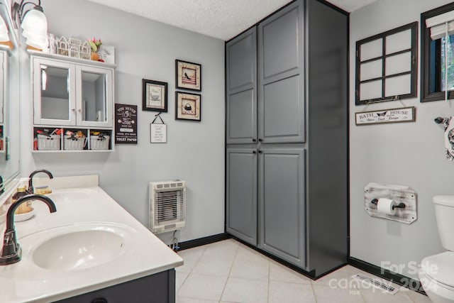 bathroom featuring vanity, toilet, tile patterned floors, and a textured ceiling