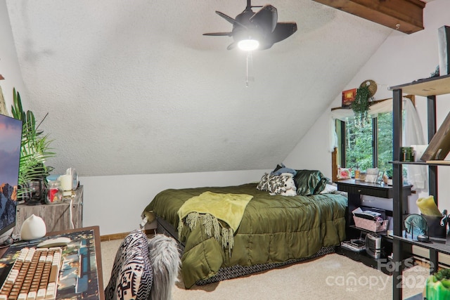 bedroom with a textured ceiling, vaulted ceiling with beams, ceiling fan, and carpet