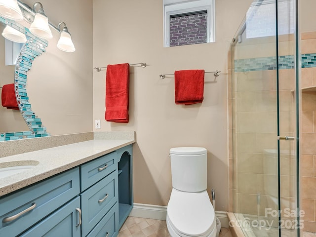 bathroom featuring a shower stall, baseboards, vanity, and toilet