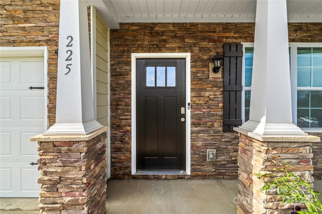 entrance to property featuring a garage and covered porch