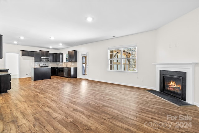 unfurnished living room featuring wood-type flooring and sink