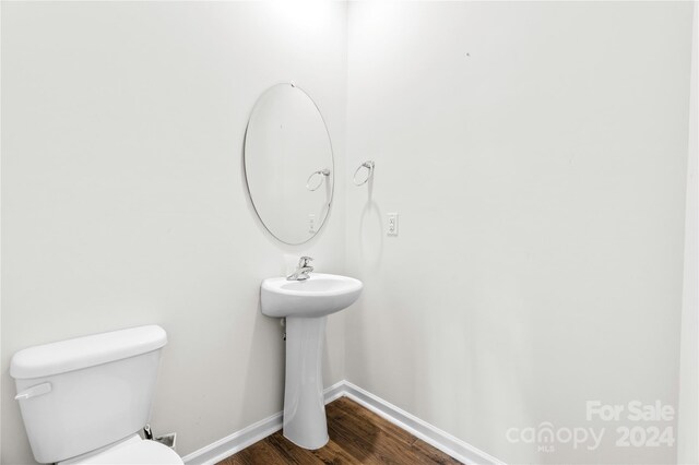 bathroom featuring toilet and wood-type flooring