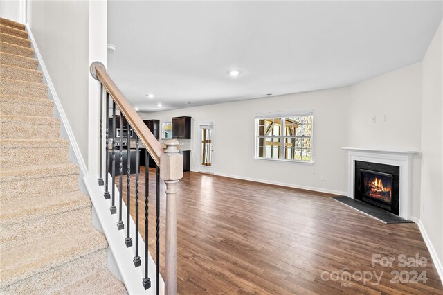 unfurnished living room featuring dark wood-type flooring and a fireplace