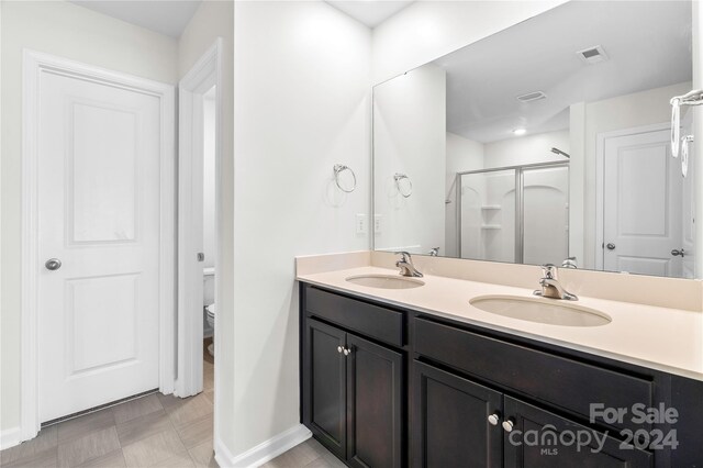 bathroom featuring vanity, toilet, and an enclosed shower