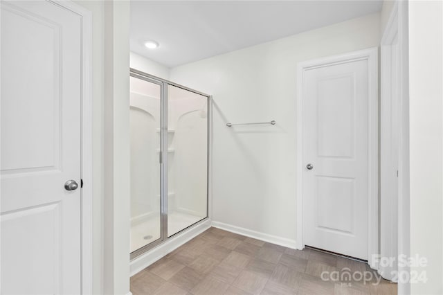 bathroom featuring a shower with door