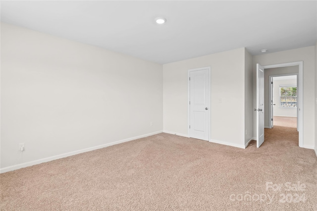 unfurnished bedroom with a closet and light carpet