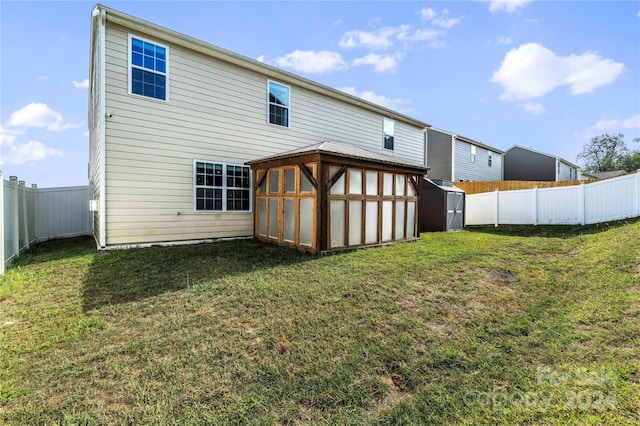 back of house with a storage unit and a yard