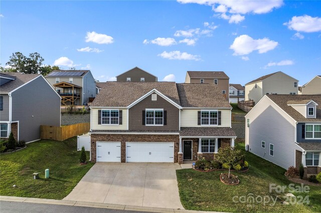 front of property featuring a balcony, a garage, and a front yard