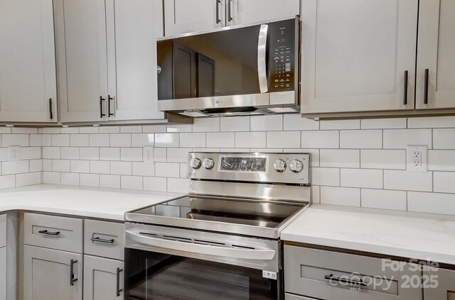 kitchen featuring backsplash, stainless steel appliances, and light countertops