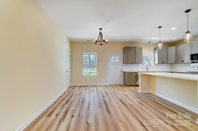 kitchen featuring decorative backsplash, plenty of natural light, appliances with stainless steel finishes, and gray cabinetry