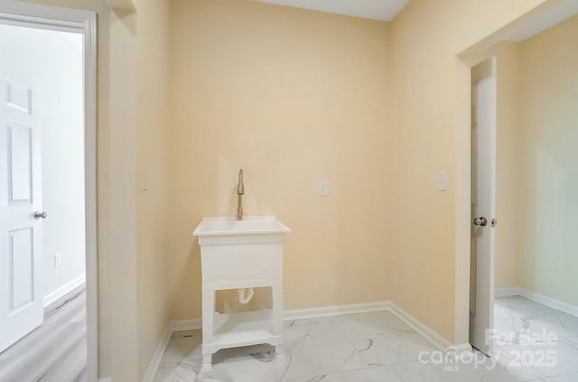 washroom with baseboards and marble finish floor