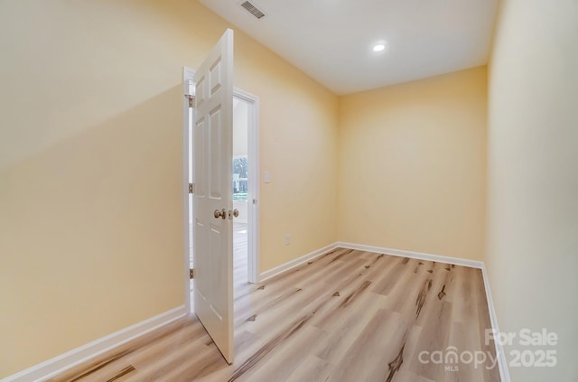 spare room featuring visible vents, baseboards, and wood finished floors