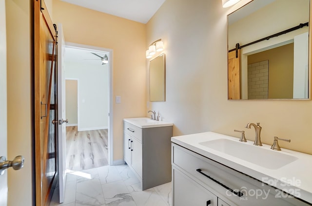 full bath featuring a sink, two vanities, marble finish floor, and ceiling fan