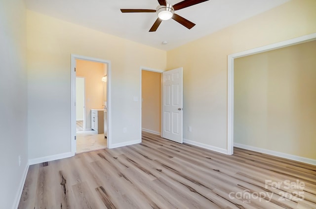 unfurnished bedroom with a ceiling fan, baseboards, light wood-type flooring, and connected bathroom