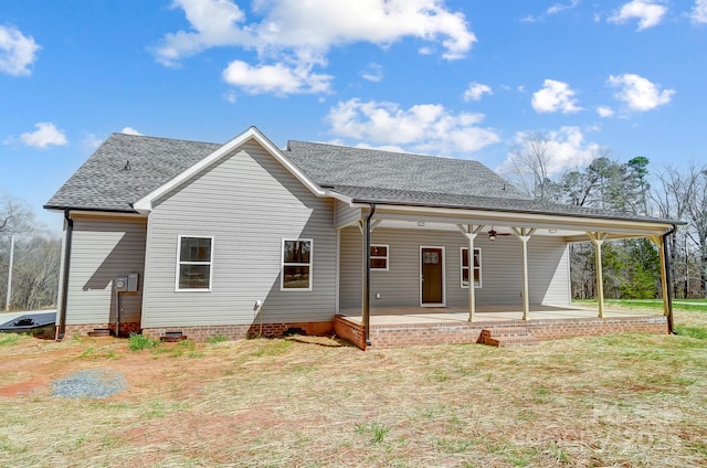 back of property featuring crawl space, a patio, a yard, and a shingled roof