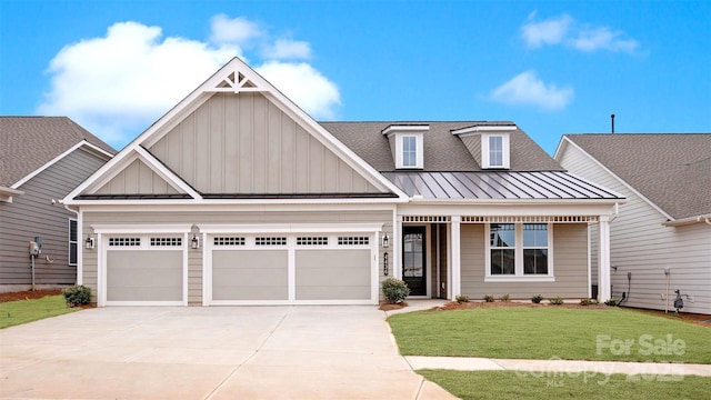 view of front of home with a shingled roof, concrete driveway, board and batten siding, a standing seam roof, and a front lawn