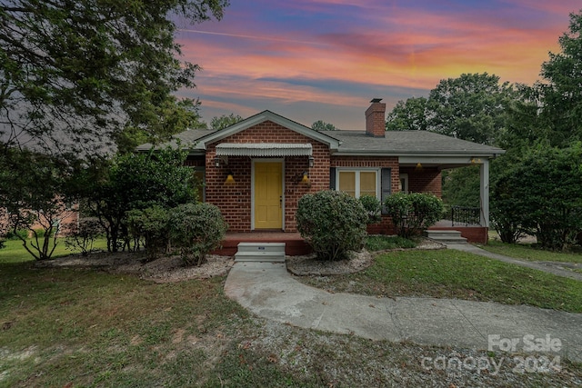 view of front facade with a yard and a porch