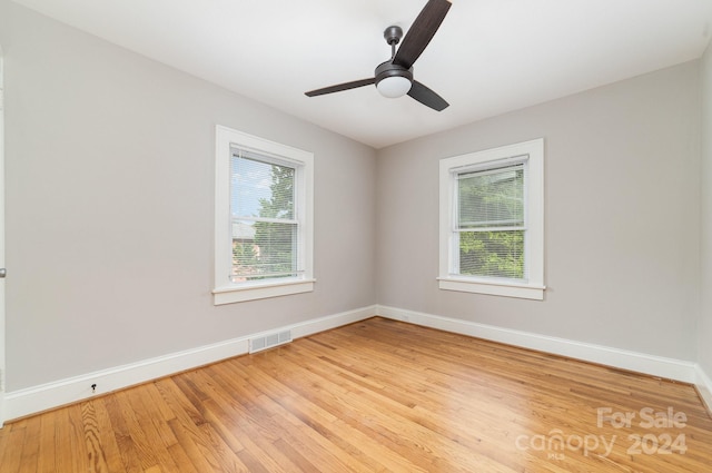 empty room featuring a healthy amount of sunlight, ceiling fan, and light hardwood / wood-style floors