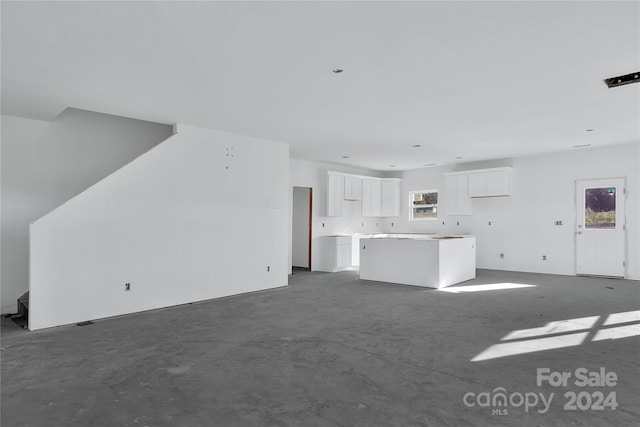 unfurnished living room featuring concrete flooring and plenty of natural light