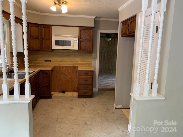 kitchen featuring a textured ceiling and crown molding