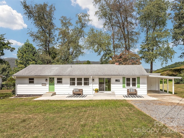 rear view of house featuring a yard and a carport