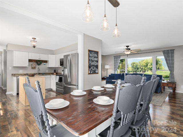 dining area with ceiling fan, dark hardwood / wood-style floors, and sink