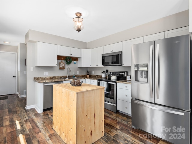 kitchen featuring appliances with stainless steel finishes, white cabinetry, sink, dark hardwood / wood-style floors, and a kitchen island