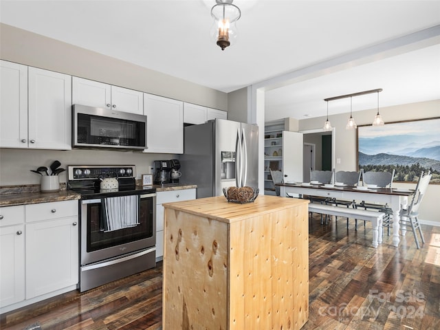 kitchen with white cabinetry, decorative light fixtures, stainless steel appliances, wooden counters, and dark hardwood / wood-style floors