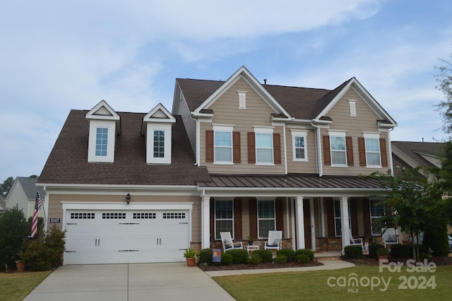 view of front facade with a front yard, a garage, and a porch