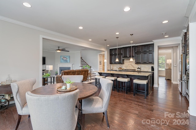 dining room with ornamental molding, ceiling fan, dark hardwood / wood-style floors, and sink