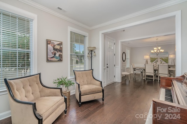 sitting room with an inviting chandelier, dark wood-type flooring, and crown molding