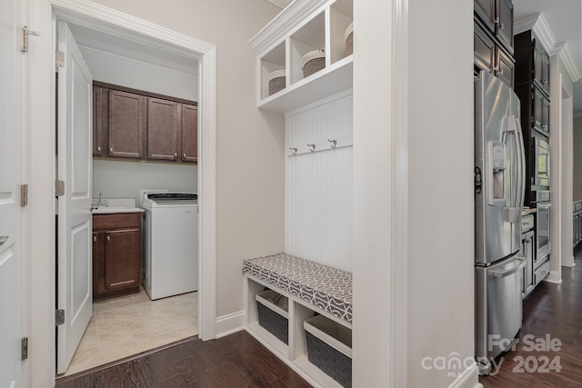 mudroom with ornamental molding, hardwood / wood-style floors, washer / dryer, and sink