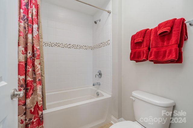 bathroom featuring shower / tub combo and toilet