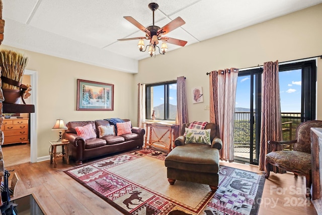 living room featuring ceiling fan, light hardwood / wood-style floors, and a textured ceiling