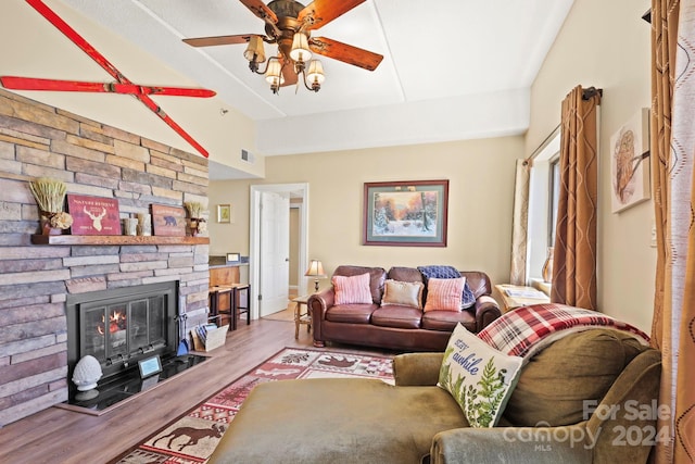 living room featuring light wood-type flooring, ceiling fan, lofted ceiling, and a fireplace