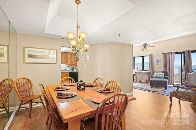 dining area featuring a textured ceiling, ceiling fan with notable chandelier, hardwood / wood-style floors, and sink