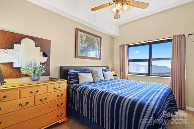 bedroom with dark colored carpet and ceiling fan