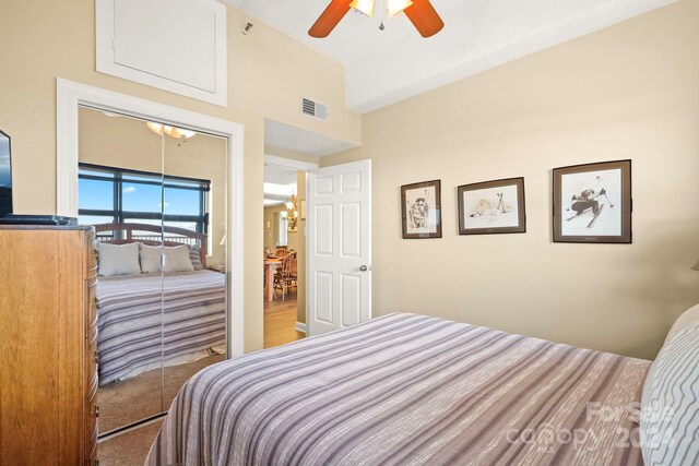 bedroom with a closet and ceiling fan with notable chandelier