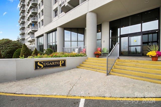 view of exterior entry with a balcony