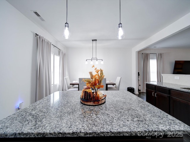 kitchen featuring pendant lighting, a center island, and light stone counters