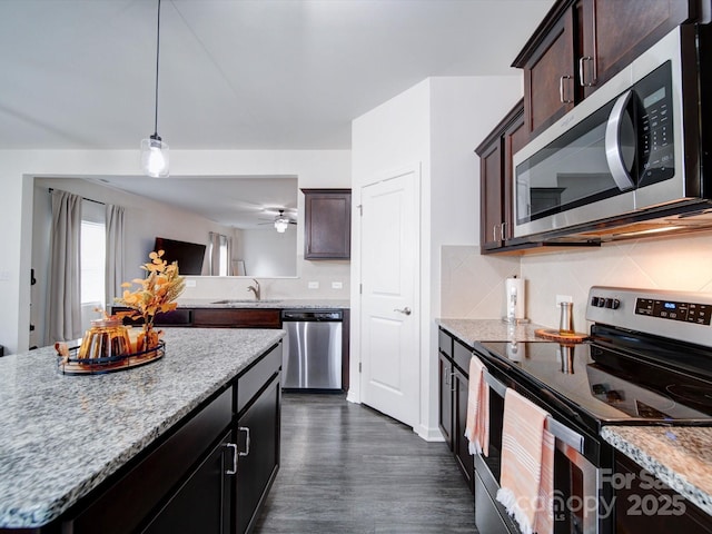 kitchen with sink, hanging light fixtures, tasteful backsplash, light stone counters, and stainless steel appliances