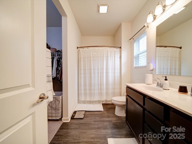 bathroom featuring wood-type flooring, vanity, toilet, and a shower with curtain