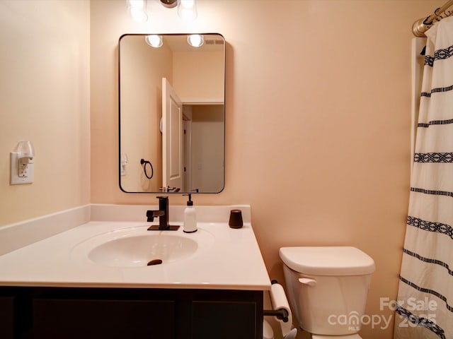 bathroom featuring walk in shower, vanity, and toilet