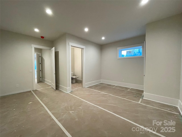 unfurnished bedroom featuring concrete flooring and ensuite bathroom