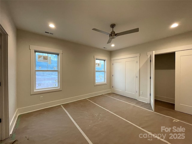 unfurnished bedroom featuring two closets and ceiling fan